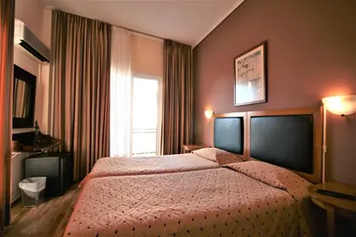 a bedroom with a bed and a window at Adams Hotel in Athens