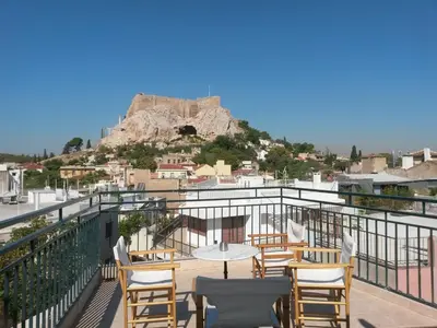 a balcony with tables and chairs and a mountain at Adams Hotel in Athens