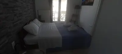 a bedroom with a bed with a blue blanket and a window at Michali's Koukaki Apartment (metro Sygrou/Fix) in Athens