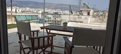 a table and chairs on a balcony with a view of a city at Michali's Koukaki Apartment (metro Sygrou/Fix) in Athens