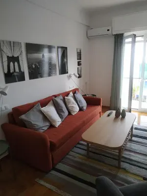 a living room with a red couch and a table at Michali's Koukaki Apartment (metro Sygrou/Fix) in Athens