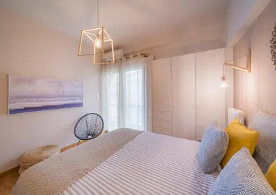 a bedroom with a bed with blue and yellow pillows at Brand new aprtm touching Acropolis in Athens