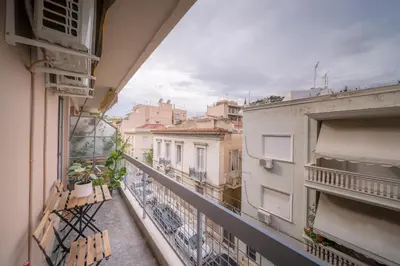 a balcony with two benches and a view of buildings at Brand new aprtm touching Acropolis in Athens