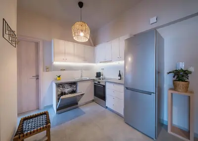 a kitchen with white cabinets and a refrigerator at Brand new aprtm touching Acropolis in Athens