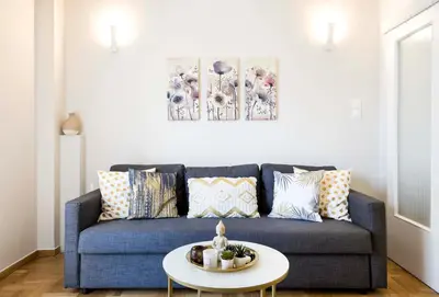 a living room with a blue couch and a table at 1 BR Apt In Petralona 15 Minutes From Acropolis in Athens