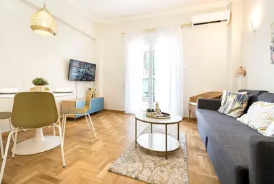 a living room with a blue couch and a table at 1 BR Apt In Petralona 15 Minutes From Acropolis in Athens
