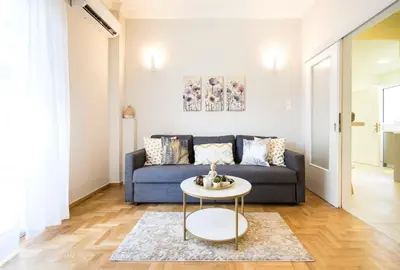 a living room with a blue couch and a table at 1 BR Apt In Petralona 15 Minutes From Acropolis in Athens