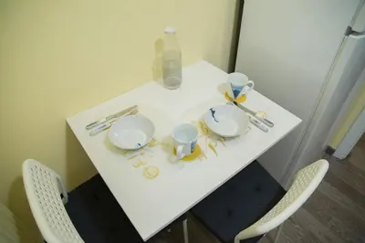 a white table with two cups and plates on it at Cozy renovated flat in Koukaki in Athens