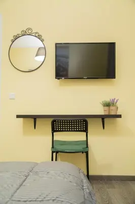 a bedroom with a desk with a tv and a chair at Cozy renovated flat in Koukaki in Athens