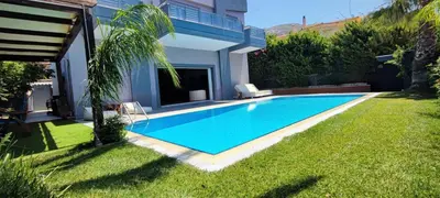 a swimming pool in the yard of a house at Unique Villa Melia Lagonisi in Kalívia Thorikoú