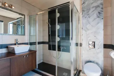 a bathroom with a glass shower and a sink at Unique Villa Melia Lagonisi in Kalívia Thorikoú