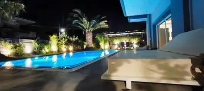 a swimming pool in the middle of a house at night at Unique Villa Melia Lagonisi in Kalívia Thorikoú