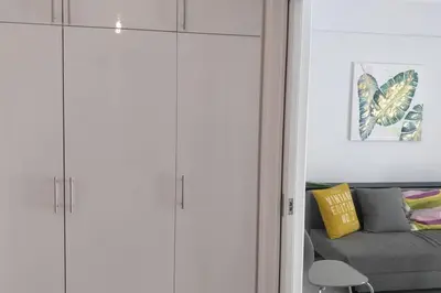 a living room with white cabinets and a couch at Ilisos garden apartment in Athens