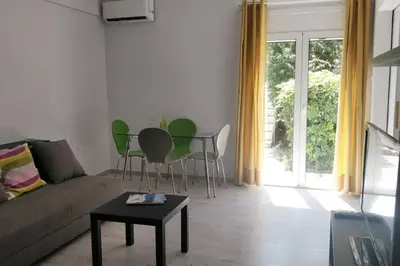 a living room with a couch and chairs and a table at Ilisos garden apartment in Athens