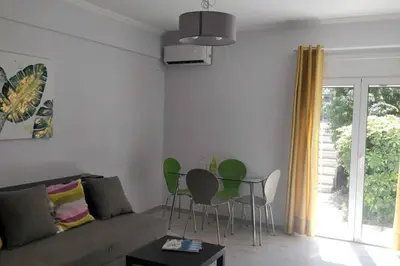 a living room with green chairs and a couch at Ilisos garden apartment in Athens
