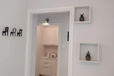 a kitchen with white cabinets and a door with plants at Ilisos garden apartment in Athens
