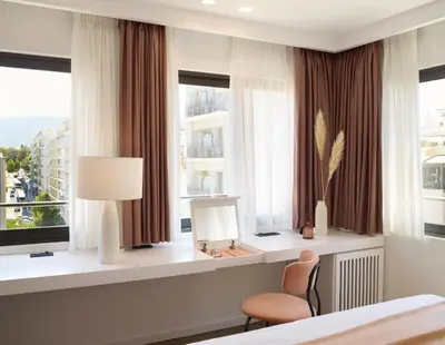 a bedroom with a bed and a chair and windows at The Marblous Athens in Athens