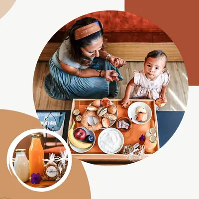 a woman and a baby sitting at a table with food at The Marblous Athens in Athens