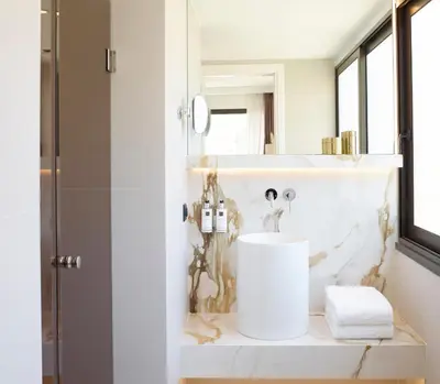 a white bathroom with a sink and a mirror at The Marblous Athens in Athens