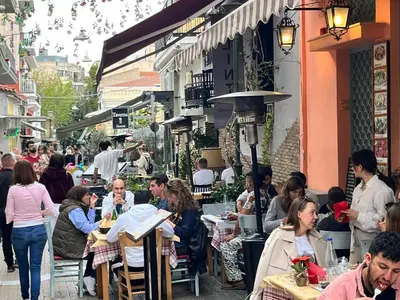 a group of people sitting at tables in a street at ARIS Piraeus Marina in Piraeus