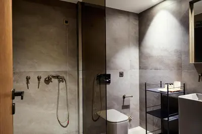 a bathroom with a shower with a toilet and a sink at Athens 1890 Hotel & Spa in Athens