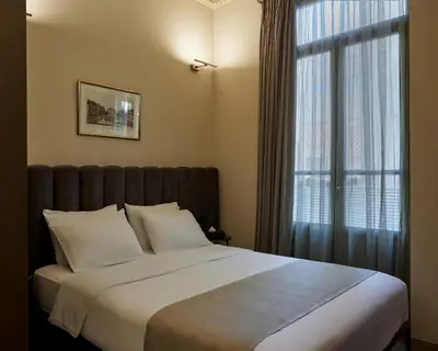 a bedroom with a large bed and a window at Athens 1890 Hotel & Spa in Athens