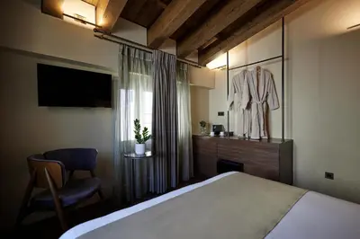 a hotel room with a bed and a dresser and a mirror at Athens 1890 Hotel & Spa in Athens