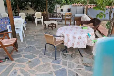 a patio with tables and chairs on a stone floor at Family House in Glyfada center in Athens