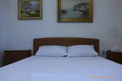 a bedroom with a bed with two pictures on the wall at Family House in Glyfada center in Athens