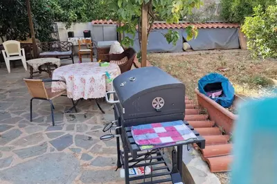 a backyard with a grill and a table and chairs at Family House in Glyfada center in Athens