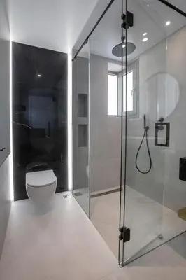 a bathroom with a toilet and a glass shower at Acropolis Golden Suites by GHH in Athens