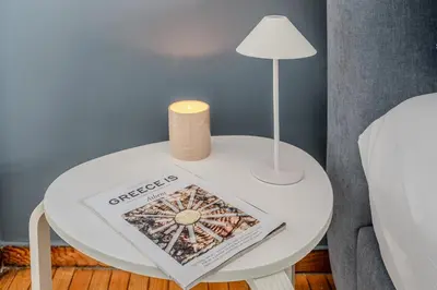 a table with a book and a lamp on it at Cozy in Athens Koukaki in Athens