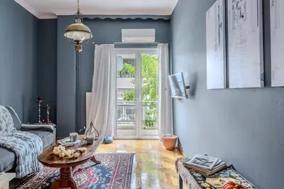 a living room with a couch and a table and a door at Cozy in Athens Koukaki in Athens