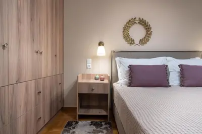 a bedroom with a bed with purple pillows and a mirror at Absolute Athens XI in Athens
