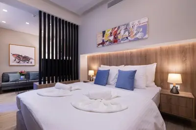 a bedroom with a large white bed with blue pillows at Hestia - Romvis 9 in Athens