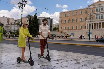 a man and a woman riding on scooters on a street at Hestia - Romvis 9 in Athens