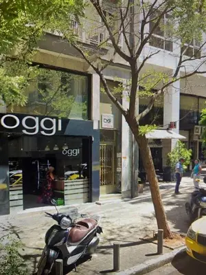 a motorcycle parked in front of a store on a street at Exclusive New Modern Apartment at Syntagma Square in Athens