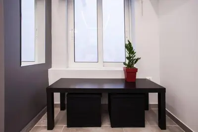 a black table in front of a window with a potted plant at Exclusive New Modern Apartment at Syntagma Square in Athens