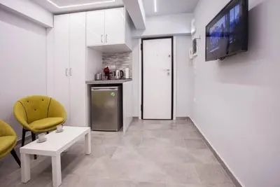 a living room with a television and a kitchen at Exclusive New Modern Apartment at Syntagma Square in Athens
