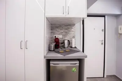 a small kitchen with white cabinets and a counter at Exclusive New Modern Apartment at Syntagma Square in Athens