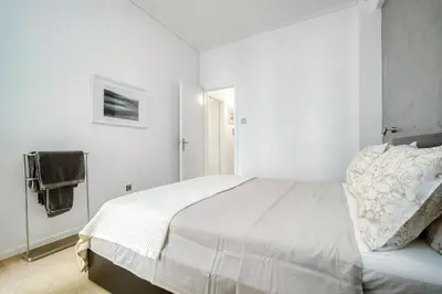 a white bedroom with a large bed and a mirror at Elegant Light Two Bedroom Apartment in City Center in Athens