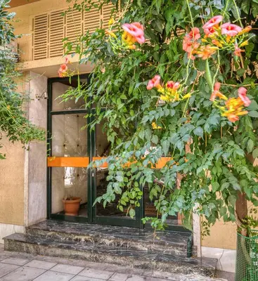 a building with a window and a bush with flowers at Elegant Light Two Bedroom Apartment in City Center in Athens