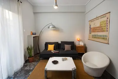 a living room with a couch and a chair at So Athens - Stylish 2 bedroom flat in Athens