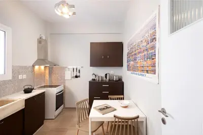 a kitchen with a table and a small kitchen with a stove at So Athens - Stylish 2 bedroom flat in Athens