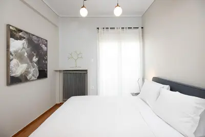 a white bedroom with a white bed and a window at So Athens - Stylish 2 bedroom flat in Athens
