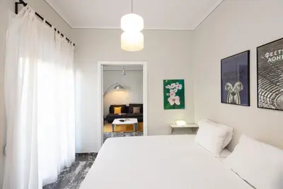 a white bedroom with a bed and a room with a desk at So Athens - Stylish 2 bedroom flat in Athens