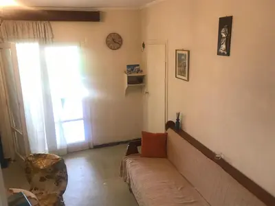 a living room with a couch and a window at Kokos Traditional Family House in Sounio