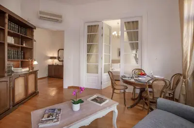 a living room with a table and a dining room at Neoclassical Apartment close to Syntagma-Plaka by GHH in Athens