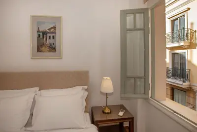 a bedroom with a bed and a table with a lamp at Neoclassical Apartment close to Syntagma-Plaka by GHH in Athens