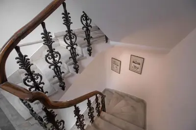a staircase in a home with a wooden rail at Neoclassical Apartment close to Syntagma-Plaka by GHH in Athens